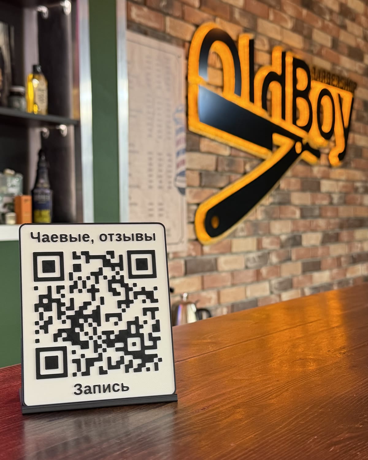 Белая QR-табличка на стойке в интерьере барбершопа
